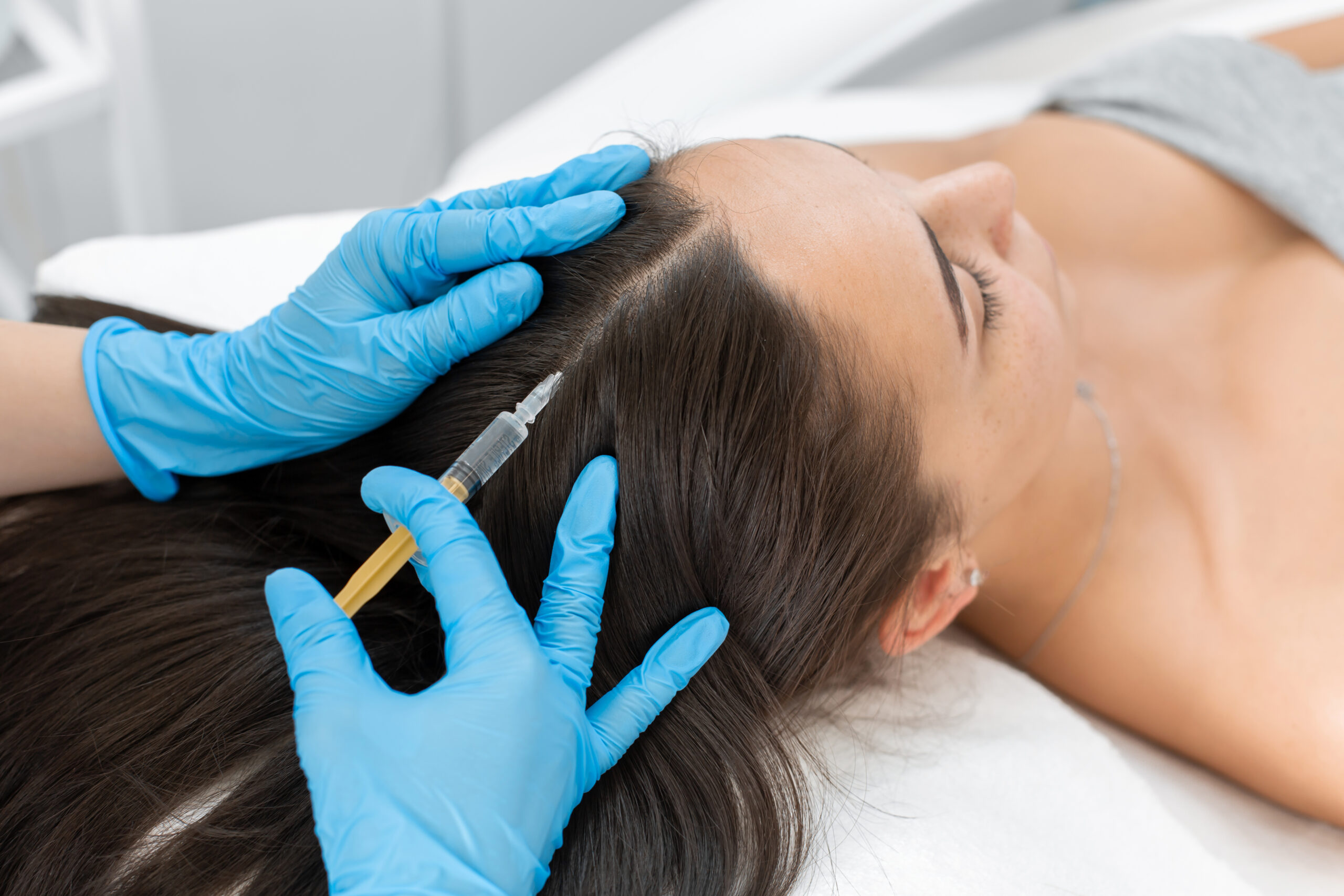 Beautician injections for healthy hair growth. Mesotherapy of the scalp. A young girl is undergoing a course of spa treatments in the office of a beautician. Moisturizing